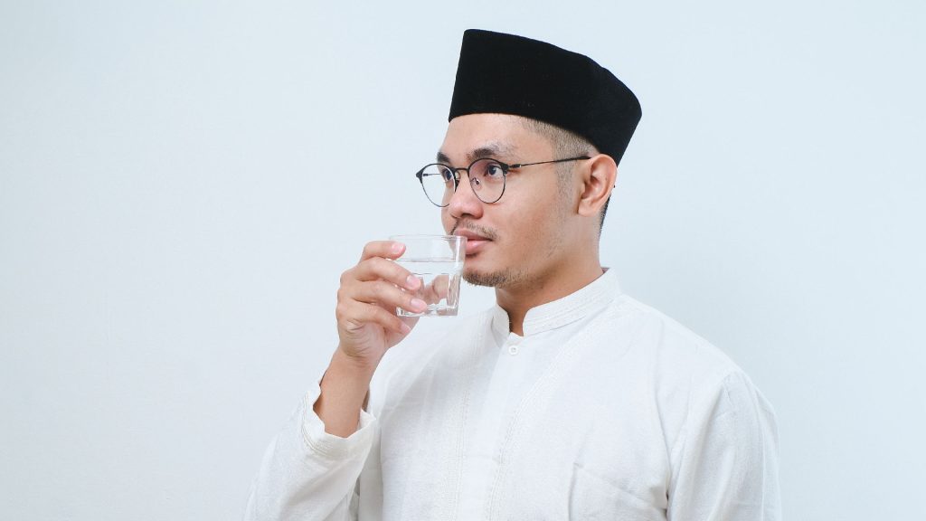 Asian person drinking water during Ramadan