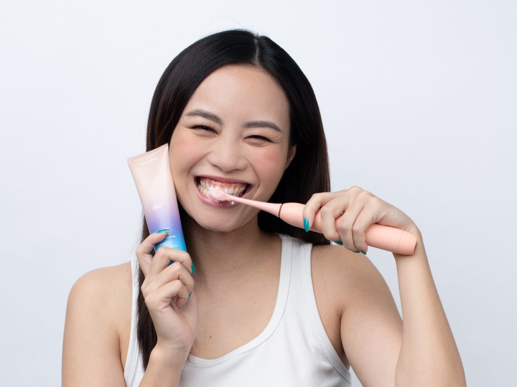 Girl using Zenyum mouthwash and Sonic Electric Toothbrush
