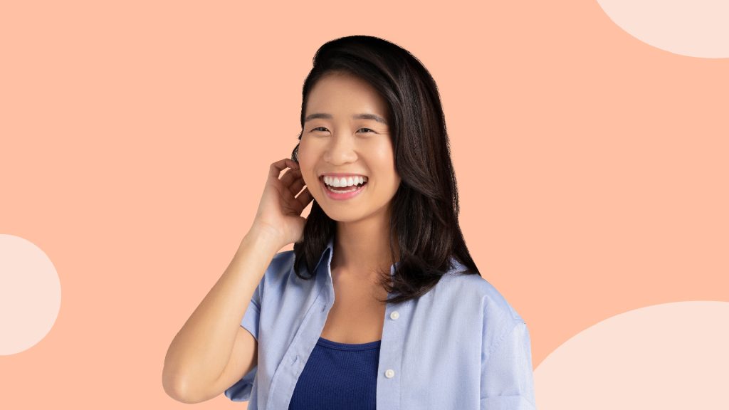 A woman touching her ear while smiling